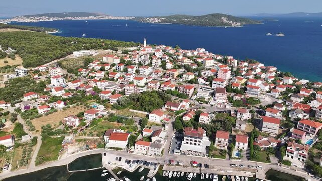 Drone showcases Seget Vranjica as a classic Dalmatian coastal village with terracotta roofs, narrow streets and Adriatic shoreline stretching beside it