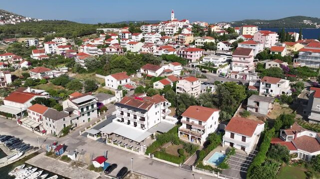 Drone captures the dual character of Seget Vranjica with fishing boats, residential areas and welcoming seaside vibe blending tourism and local lifestyle