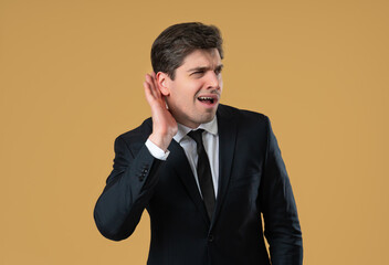 Businessman pointing to ear and asking what with confused expression, mishearing