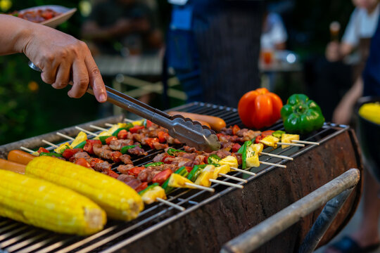 Grilling vegetables and meat skewers outdoors with corn and peppers - Powered by Adobe