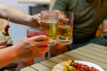 People toasting with drinks and enjoying skewers at gathering