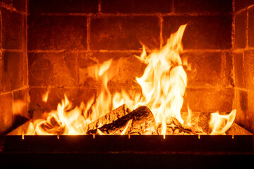 Burning fireplace logs with high flames inside brick hearth, cozy interior warmth, traditional home heating, rustic ambiance, romantic cabin atmosphere, winter season comfort, firewood crackling sound