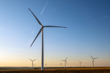 Renewable wind farm in rural region, turbines spinning under clear sky, producing clean energy without emissions, supporting environmental sustainability goals, future of energy captured in scenic