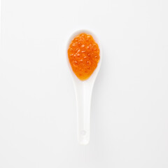 Red caviar on white ceramic spoon caviar, seafood duo presentation, gourmet minimalist style,...