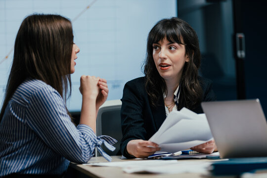 Young female colleague receives mentorship at a meeting in office