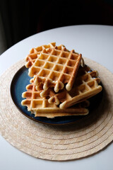 belgian waffles on a plate, round napkin and white table