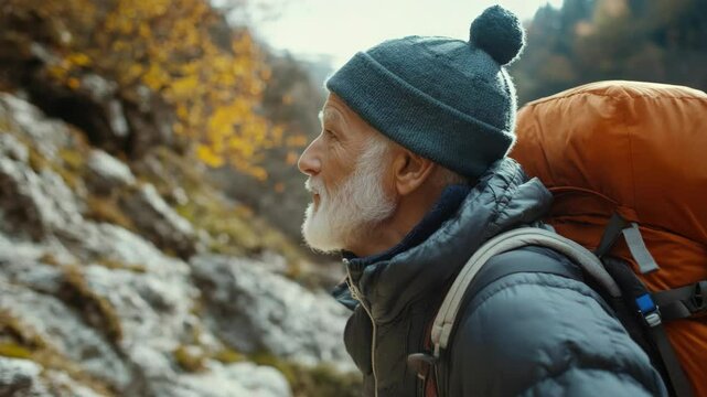 Grey-haired man hiking on mountain trail with backpack, conveying the message of active and adventurous seniors.