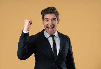 Businessman in suit is very glad and happy, he shows yes gesture of victory with clenched fist, guy...