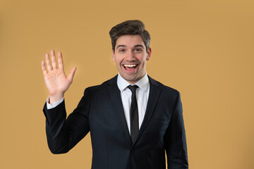 Friendly American Mature 30s aged businessman Waving Hand - Hello, Hi, salute, chao. Greetings on beige studio. © kohanova1991