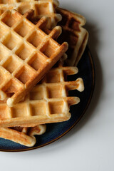 belgian waffles on blue plate and white table