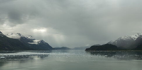Glacier Bay Alaska with a Moody Cloudy Sky Sun Rays and Icebergs. 