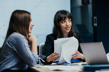 Female colleagues listening attentively to opinion during business meeting in office