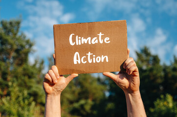 Climate Action Rally: Man Holding Sign Against Blue Sky