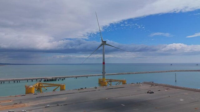 Wind Turbine Standing on Floating Platform at Coastal Construction Site