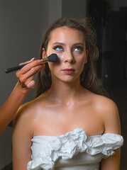 Beauty portrait featuring a woman with shiny makeup and golden accessories. Soft lighting enhances...