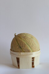 Whole Galia Melon in Wooden Basket on White Background