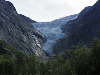 A blue glacier between mountains.