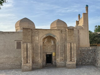 Famous ancient mosque with its beautiful designed walls, wooden door and dome in Bukhara, Uzbekistan