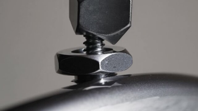 Detailed Close-up of Metal Fastener with Threaded Rod and Hex Bolt against a Dark Background