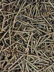 pile of screws, bronze, gold screws close-up, buying screws by weight in a store