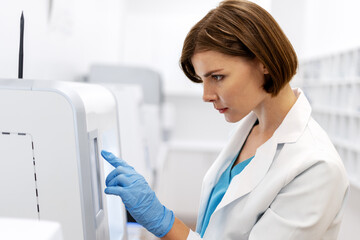 Scientist using touchscreen of modern medical equipment in laboratory