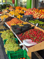 Abundant Outdoor Fruit Market Display with Strawberries, Grapes, and Pineapples