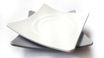 Stack of empty square white and grey plates with ceramic melamin material isolated on white background