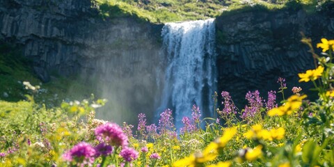 Naklejka premium A waterfall framed by blooming wildflowers in spring