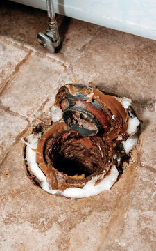 Vertical macro shot of wax ring seated on toilet flange with copy space.