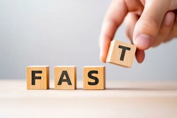 A hand is placing the letter T onto wooden blocks spelling out the word FAST, symbolizing speed, efficiency, and progress in various contexts, including business and personal growth.