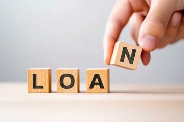 A hand placing a letter on wooden blocks spelling the word LOAN, representing financial services, lending, and borrowing, highlighting business and personal finance themes to inspire trust and growth.