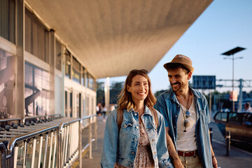 Happy tourist couple coming to the airport terminal.