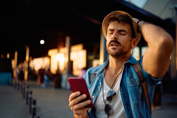 Upset man checking his cell phone at the airport.