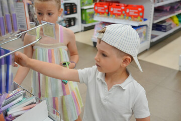 Brother and sister choose school accessories for school at the market