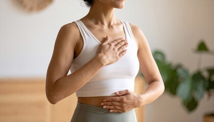 Woman practicing mindful breathing, hands gently resting on her chest and abdomen, promoting relaxation and inner peace.