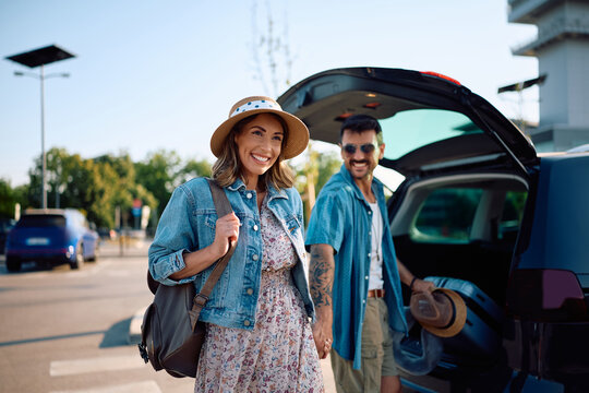 Happy woman and her boyfriend on parking lot at the airport.