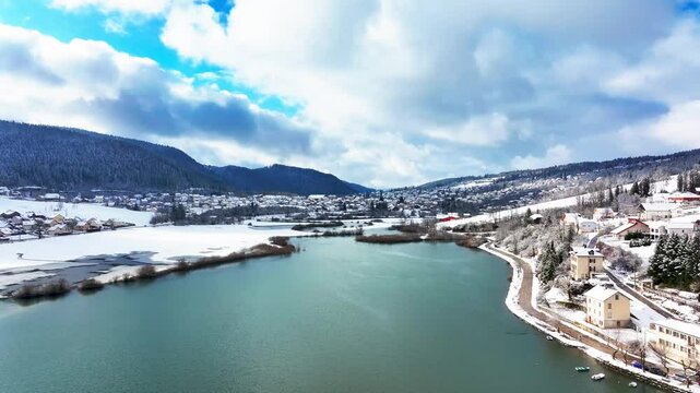 Aerial view of winding River Doubs in snowy landscape, France.