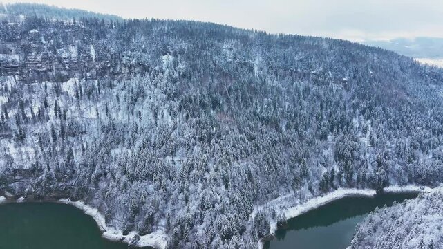 Aerial view of River Doubs and snowy forest in winter, France.