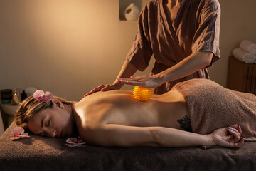 Professional Back Massage Using Massage Ball for Muscle Relief and Relaxation in Spa Setting