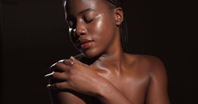 Beauty, skincare and touching with black woman in studio on dark background to appear from shadow. Aesthetic, dermatology and lighting with serious model person in shade for change or transformation
