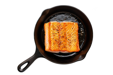 Salmon fillet cooking in a cast iron skillet with image