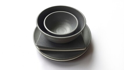 Stack of empty circle grey bowls and empty white grey  square plates with ceramic melamin material isolated on white background. Utensils kitchen concept