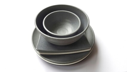 Stack of empty circle grey bowls and empty white grey  square plates with ceramic melamin material isolated on white background. Utensils kitchen concept