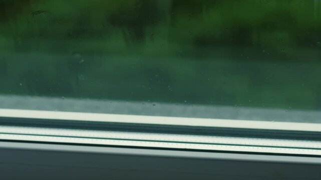 drops of heavy rain fall on the cornice outside the window on a rainy summer day, heavy rain outside the window during the day