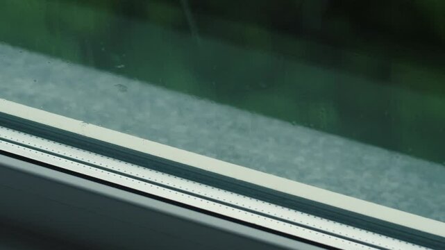 drops of heavy rain fall on the cornice outside the window on a rainy summer day, heavy rain outside the window during the day