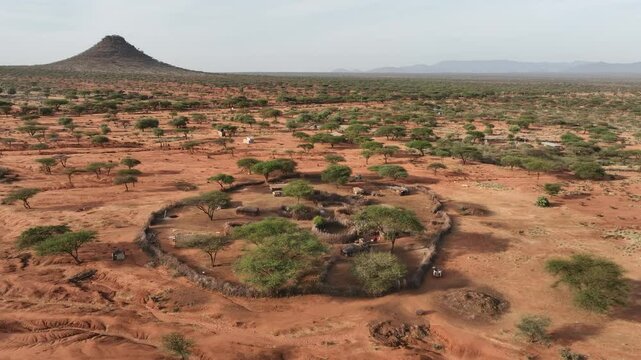 Aerial view of rural settlement under the soft light, with huts nestled among trees and a distant hill, creating a tranquil scene, Sauka, Federal Capital Territory, Nigeria.