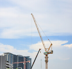 construction tower crane work with construction worker on top of building, used in construction site with blue sky.