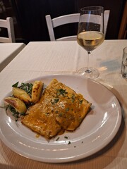 Huge raviolli in a restaurant in Rome with a glass of white wine