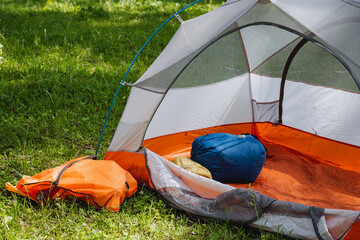 Enjoy a Cozy Camping Tent Setup Nestled on Lush Green Grass with Comfortable Sleeping Gear and all...