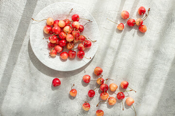 yellow cherries on a white platter, scattered on the table, natural light, top view,